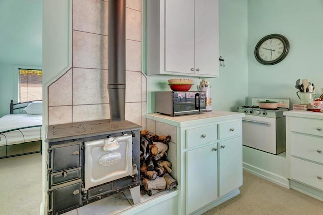 kitchen featuring white range with gas cooktop and white cabinets