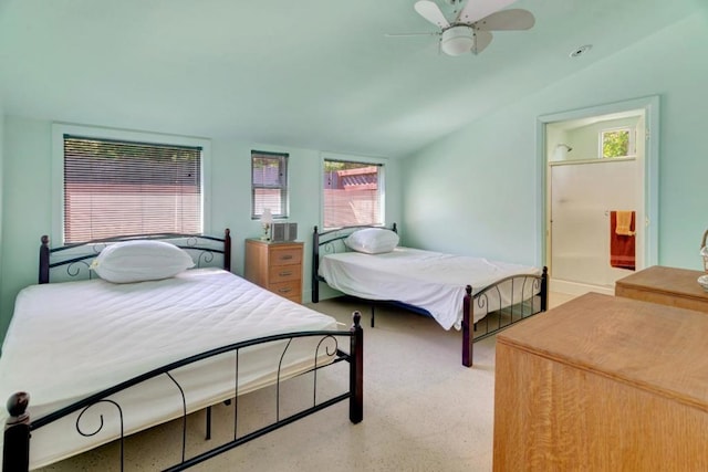 bedroom featuring ceiling fan, lofted ceiling, and ensuite bathroom