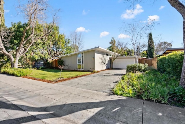 ranch-style house featuring a garage and a front lawn