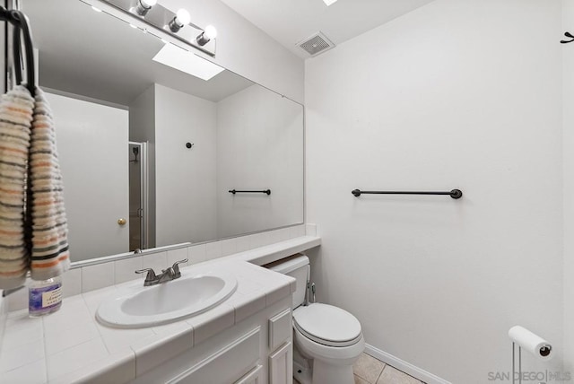 bathroom featuring vanity, tile patterned floors, and toilet