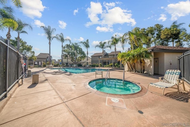 view of pool with a hot tub and a patio area