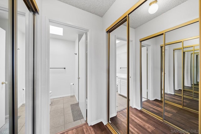 corridor with wood-type flooring and a textured ceiling