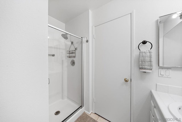 bathroom featuring vanity, tile patterned floors, and a shower with door