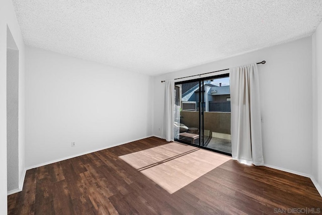 unfurnished room with dark hardwood / wood-style floors and a textured ceiling