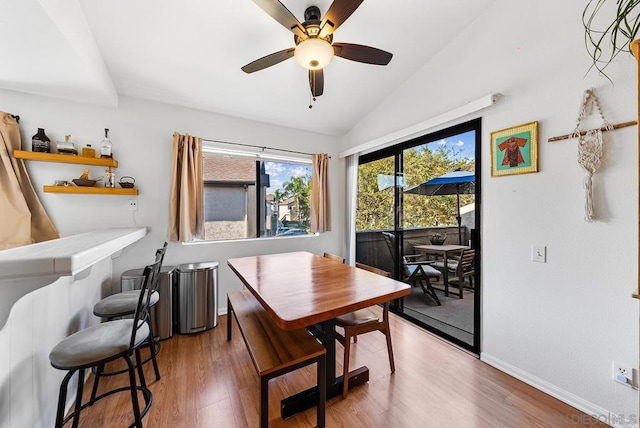 dining room featuring hardwood / wood-style flooring, vaulted ceiling, and ceiling fan