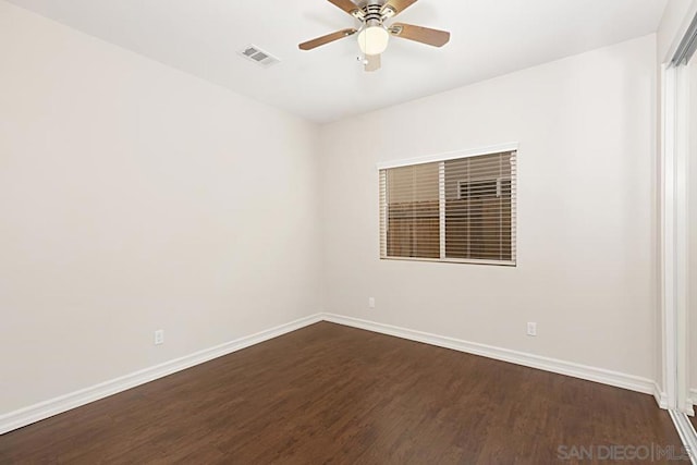 empty room with dark hardwood / wood-style flooring and ceiling fan