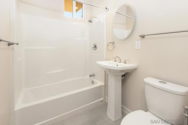 bathroom featuring tub / shower combination and toilet