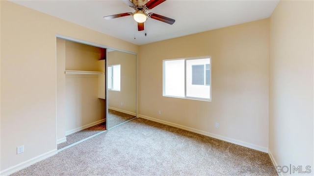 unfurnished bedroom featuring ceiling fan, a closet, and light carpet