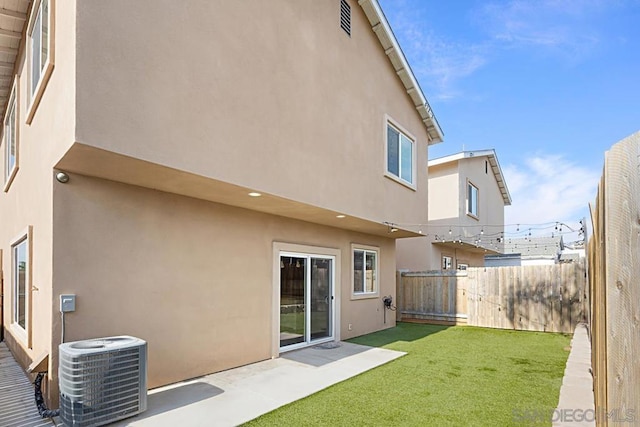 back of property with central AC, a yard, and a patio