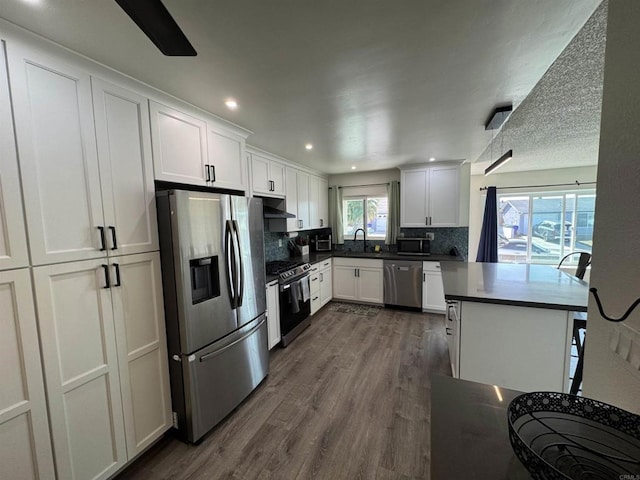 kitchen with white cabinetry, tasteful backsplash, stainless steel appliances, and dark hardwood / wood-style floors