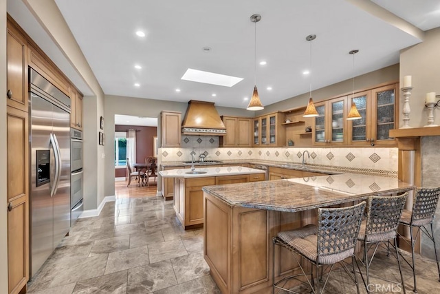 kitchen featuring appliances with stainless steel finishes, pendant lighting, a breakfast bar area, kitchen peninsula, and custom range hood