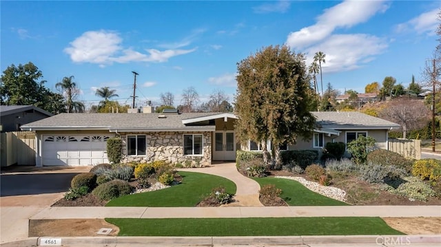 ranch-style house featuring a garage and a front lawn