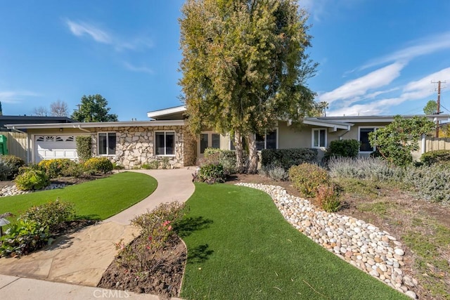 single story home featuring a garage and a front yard