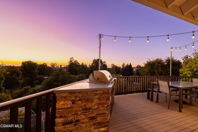 deck at dusk with grilling area