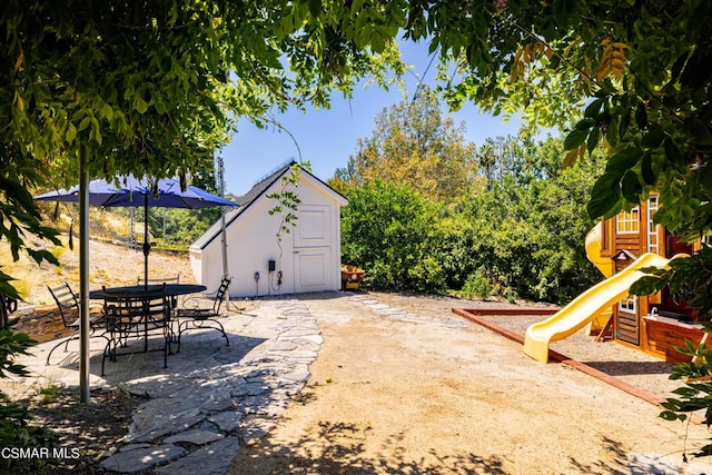 view of patio / terrace featuring a playground and a shed