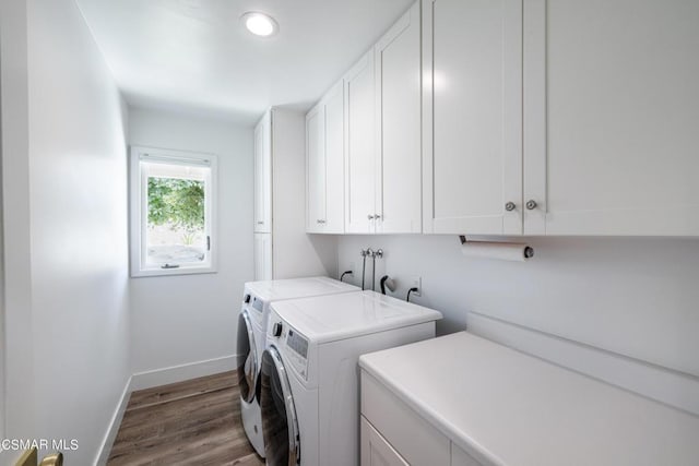 washroom with cabinets, independent washer and dryer, and light hardwood / wood-style floors