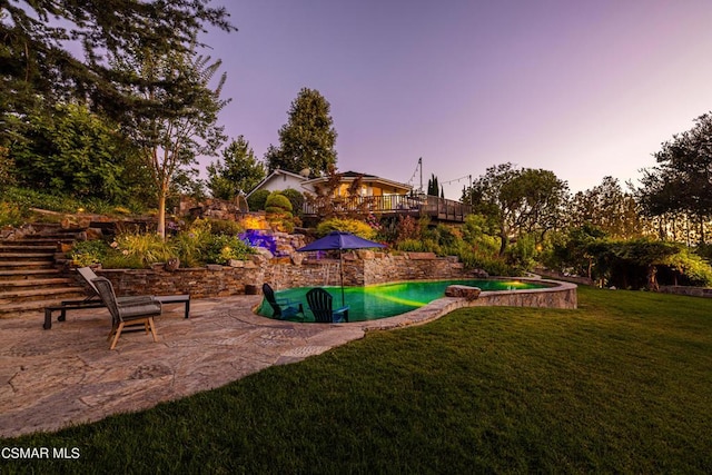 view of property's community with a pool, a patio, and a lawn