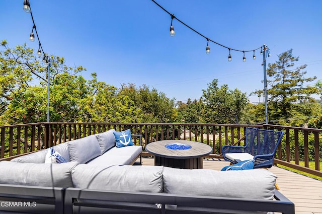 wooden terrace featuring an outdoor living space with a fire pit