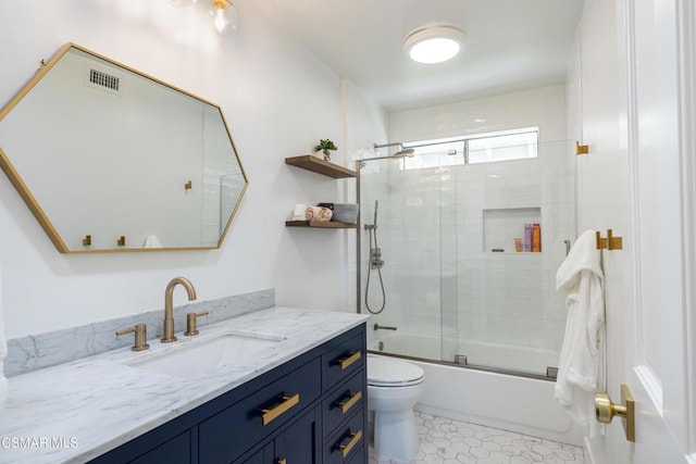 full bathroom with enclosed tub / shower combo, vanity, and toilet