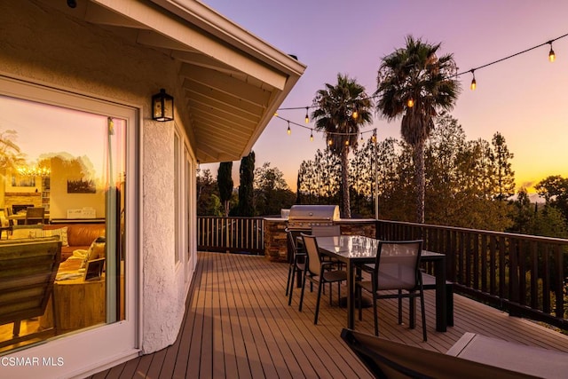 deck at dusk featuring grilling area