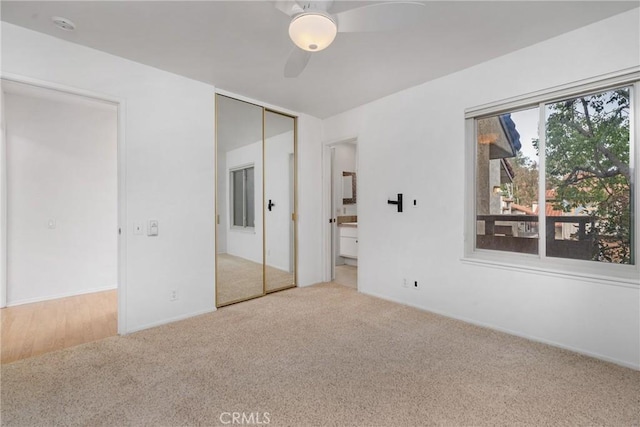 unfurnished bedroom with light carpet, ensuite bath, and ceiling fan