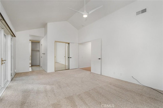 unfurnished bedroom featuring ceiling fan, light carpet, and high vaulted ceiling