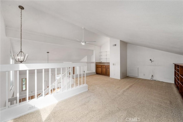 bonus room with lofted ceiling, ceiling fan with notable chandelier, and light carpet