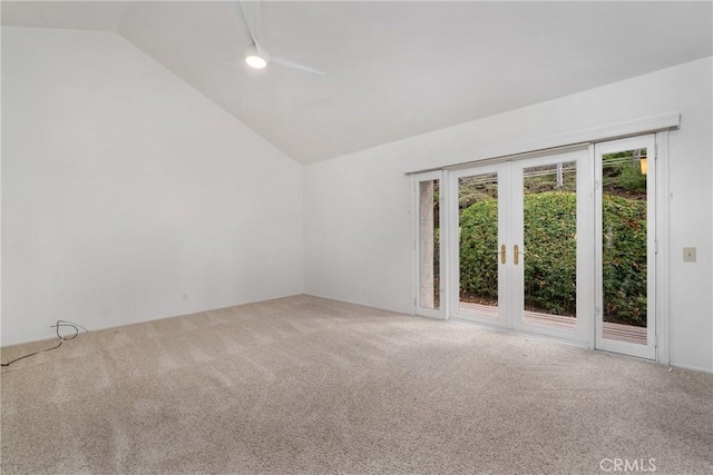 carpeted empty room featuring lofted ceiling and french doors