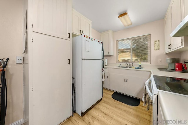 kitchen featuring white cabinetry, sink, white appliances, and light hardwood / wood-style floors