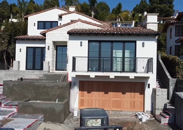 rear view of house featuring a balcony and a garage