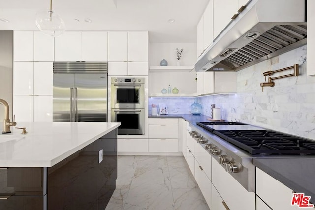 kitchen featuring white cabinetry, appliances with stainless steel finishes, range hood, and hanging light fixtures