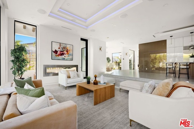 carpeted living room with a tray ceiling