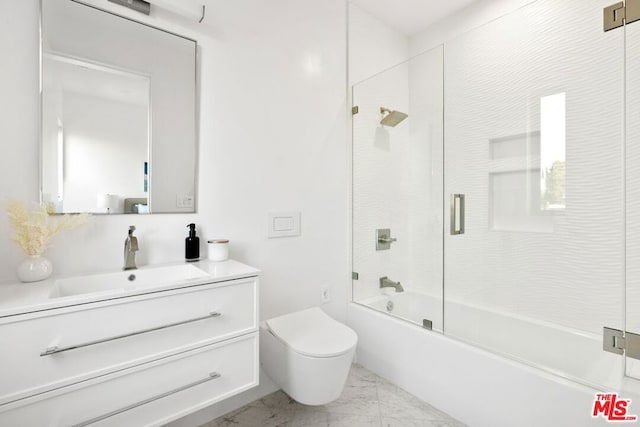 full bathroom featuring vanity, bath / shower combo with glass door, and toilet