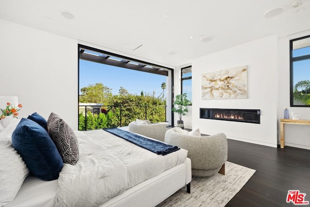 bedroom with multiple windows and dark hardwood / wood-style floors