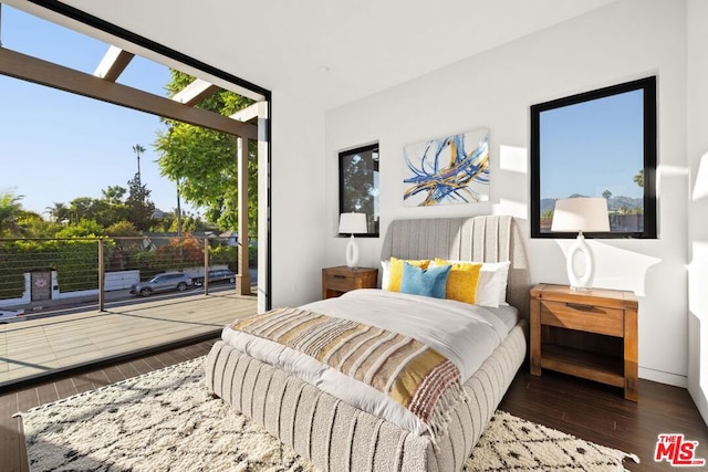 bedroom with dark wood-type flooring and access to outside