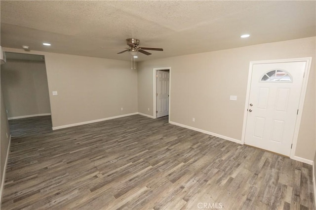 interior space featuring ceiling fan, dark wood-type flooring, and a textured ceiling