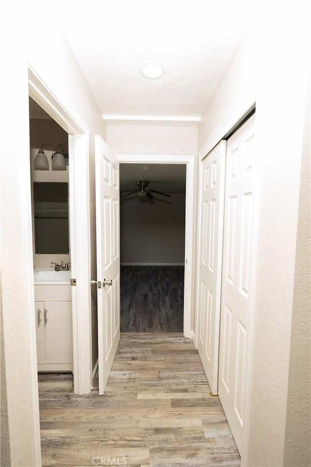 hallway with sink and light wood-type flooring