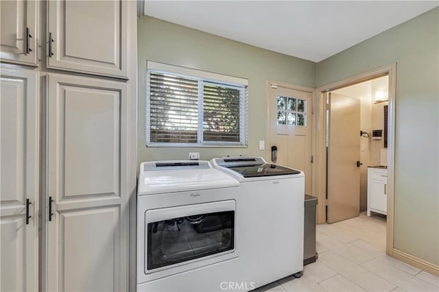 washroom featuring washer and clothes dryer and cabinets