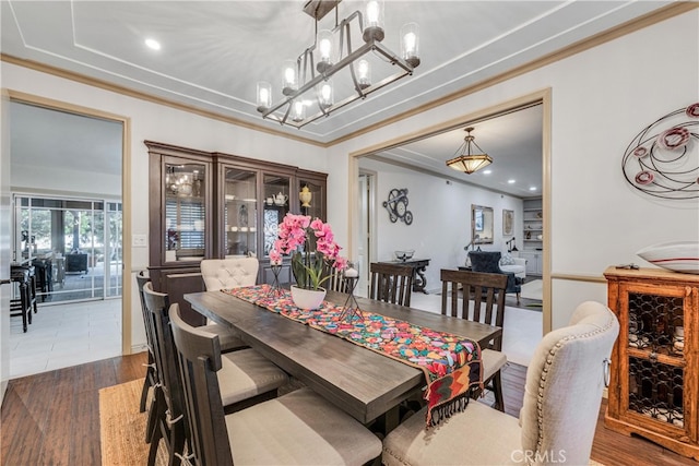 dining space featuring crown molding, dark wood-type flooring, and a notable chandelier