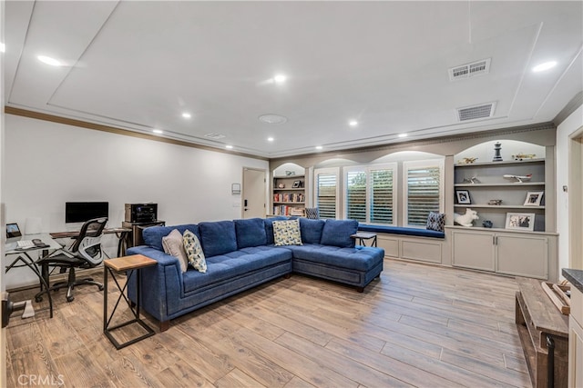 living room with crown molding, light hardwood / wood-style floors, and built in shelves