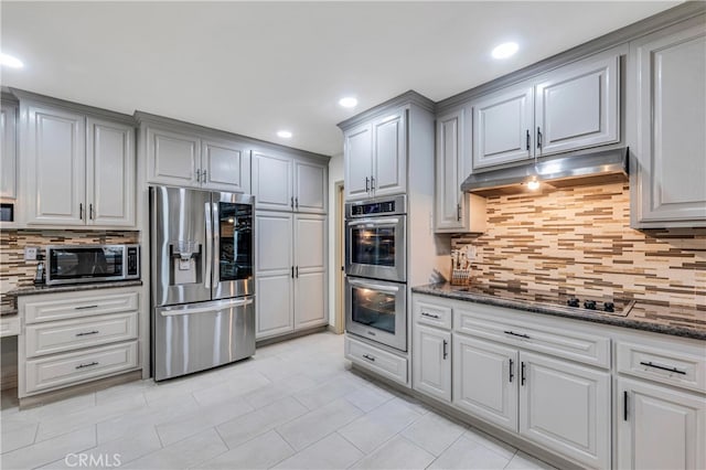 kitchen featuring gray cabinets, appliances with stainless steel finishes, dark stone countertops, and decorative backsplash