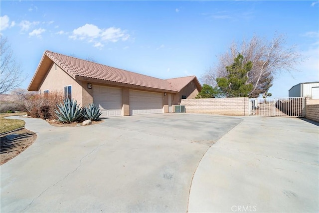 view of property exterior with cooling unit and a garage