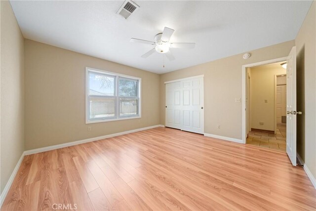 unfurnished bedroom featuring light hardwood / wood-style flooring, a closet, and ceiling fan