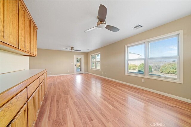 unfurnished living room featuring ceiling fan and light hardwood / wood-style flooring