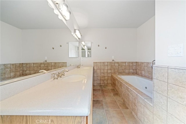 bathroom featuring tiled tub, vanity, and tile patterned floors