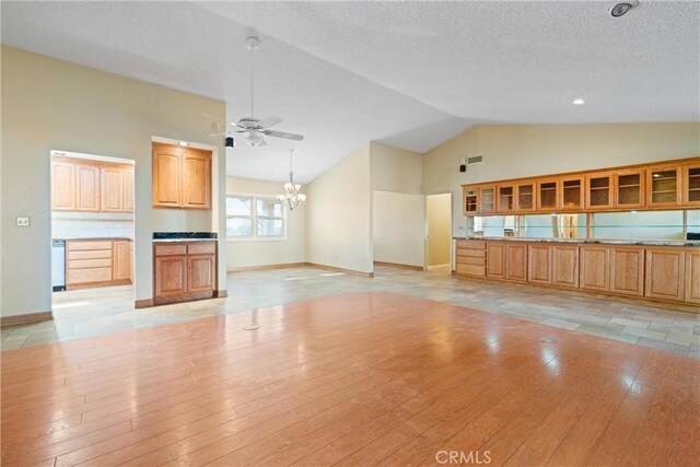 unfurnished living room featuring high vaulted ceiling, ceiling fan with notable chandelier, light hardwood / wood-style floors, and a textured ceiling