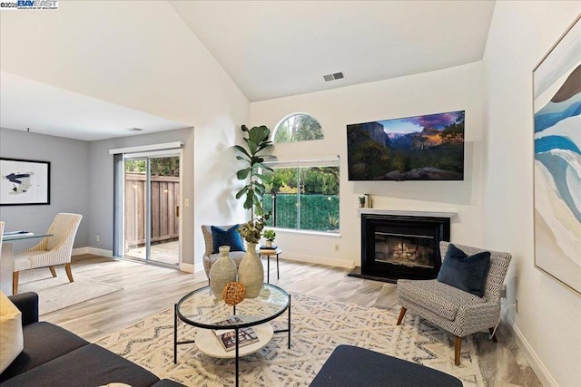 living room with light hardwood / wood-style flooring and high vaulted ceiling