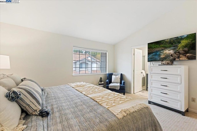 carpeted bedroom featuring connected bathroom and vaulted ceiling