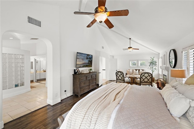 bedroom featuring multiple windows, wood-type flooring, and high vaulted ceiling