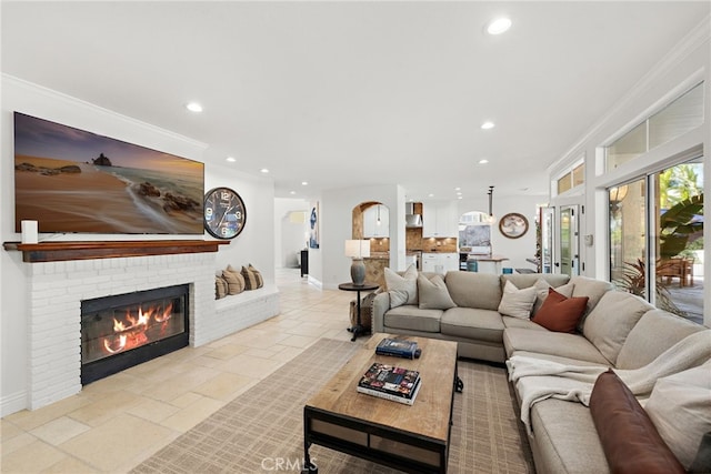 living room with crown molding, a brick fireplace, and french doors